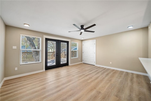 empty room featuring light wood-style floors, baseboards, french doors, and ceiling fan