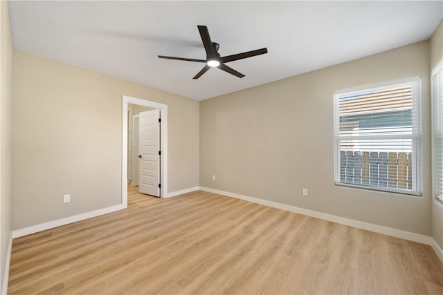 empty room with a ceiling fan, baseboards, and light wood-type flooring