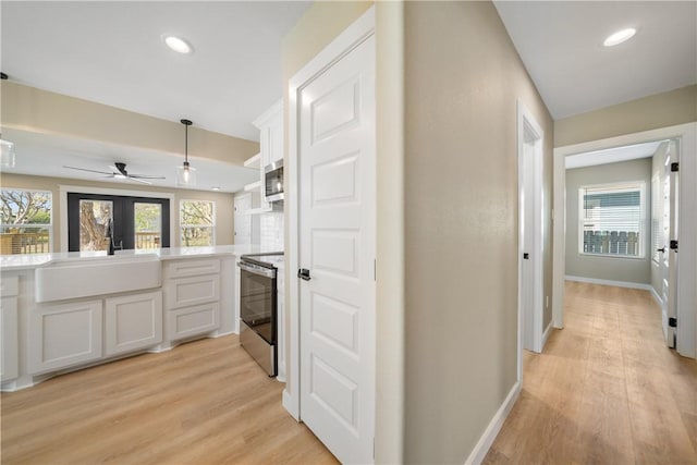 kitchen with a sink, plenty of natural light, appliances with stainless steel finishes, and white cabinets