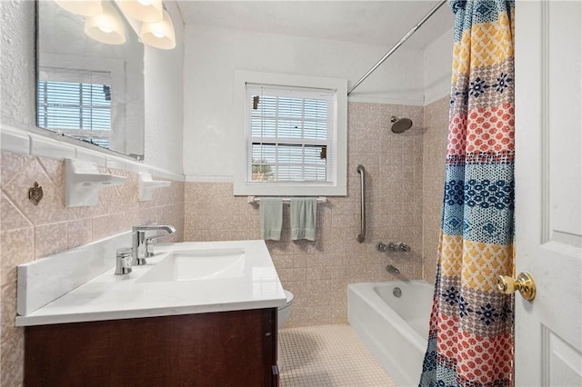 bathroom with tile patterned flooring, tile walls, vanity, and shower / tub combo