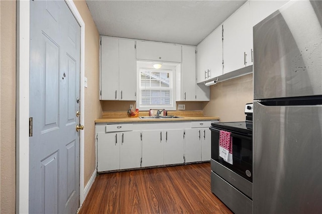 kitchen featuring appliances with stainless steel finishes, dark wood-type flooring, sink, and white cabinets