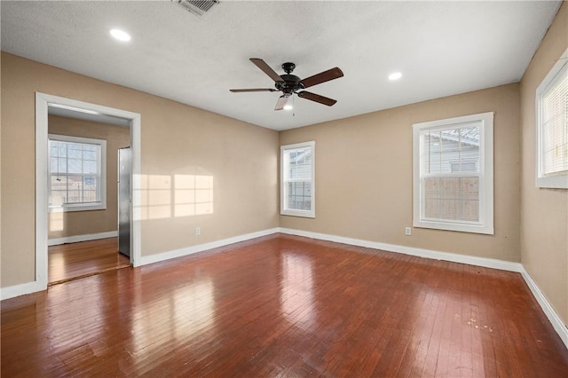 unfurnished room featuring hardwood / wood-style floors, a wealth of natural light, and ceiling fan