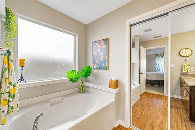 7217 Dunns Point Dr, Corpus Christi, TX 78414 - full bath with vanity, a bath, wood finished floors, and ensuite bathroom