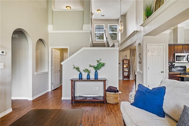 7217 Dunns Point Dr, Corpus Christi, TX 78414 - living room with a towering ceiling, arched walkways, wood finished floors, and stairs