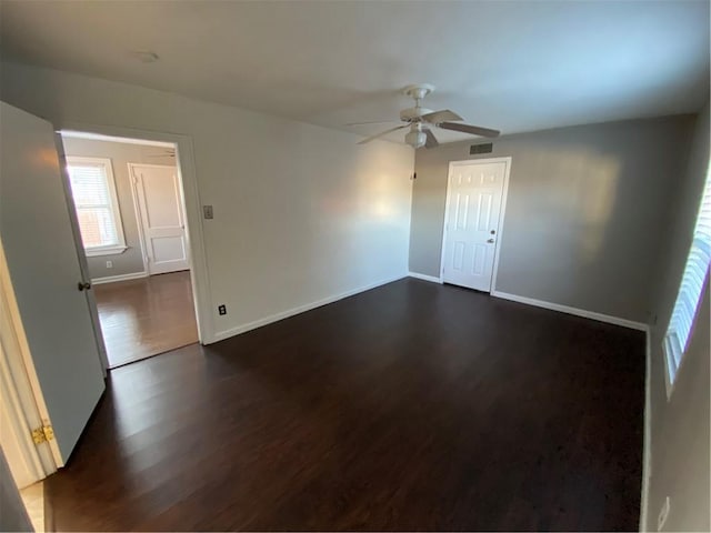 empty room featuring ceiling fan and dark wood-type flooring