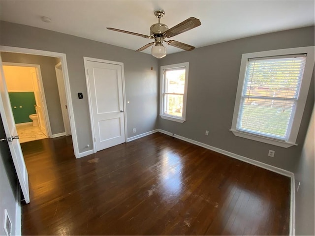 unfurnished bedroom with ensuite bath, ceiling fan, and dark hardwood / wood-style floors