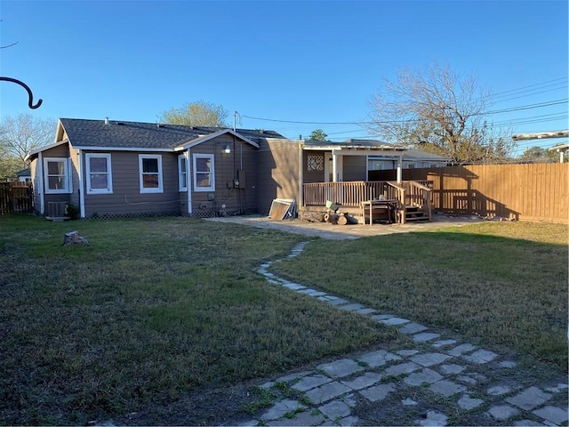 rear view of house with a yard, a deck, and central AC unit