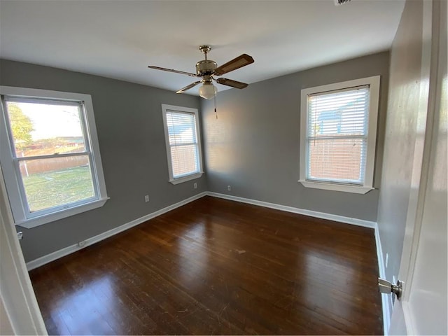 empty room with dark hardwood / wood-style floors and ceiling fan