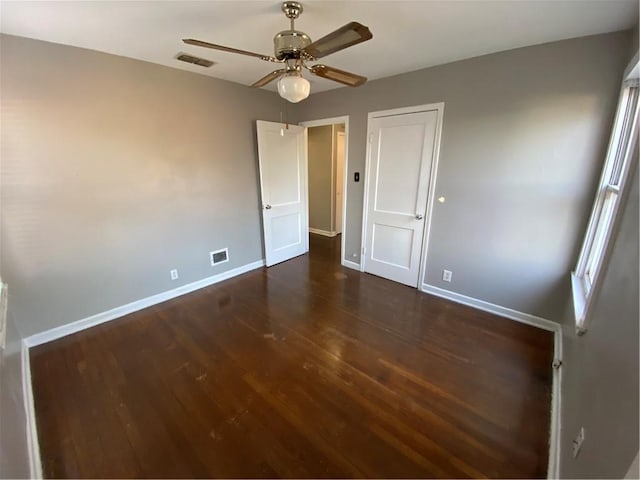 unfurnished bedroom featuring ceiling fan and dark hardwood / wood-style floors