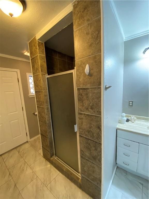 bathroom with crown molding, vanity, and an enclosed shower