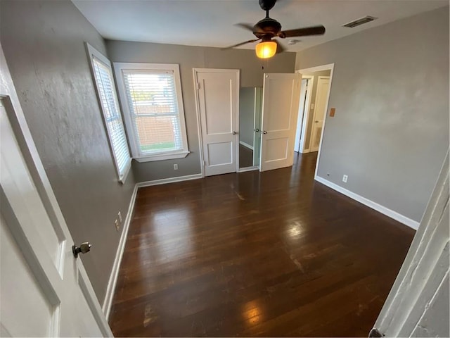 unfurnished bedroom with ceiling fan and dark hardwood / wood-style floors