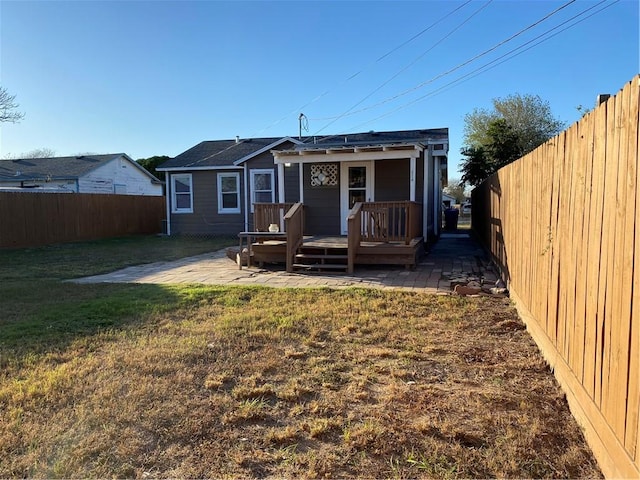 back of property featuring a lawn, a patio, and a deck