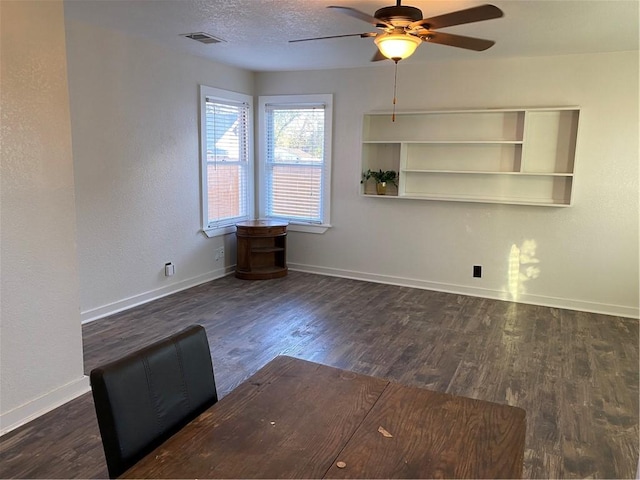 interior space with ceiling fan, dark hardwood / wood-style floors, built in features, and a textured ceiling