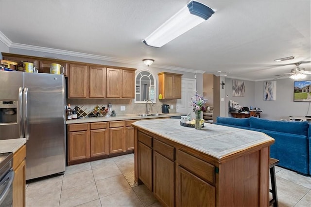 3901 Gibraltar Dr, Corpus Christi, TX 78414 - kitchen featuring stainless steel fridge, a sink, tile countertops, open floor plan, and crown molding