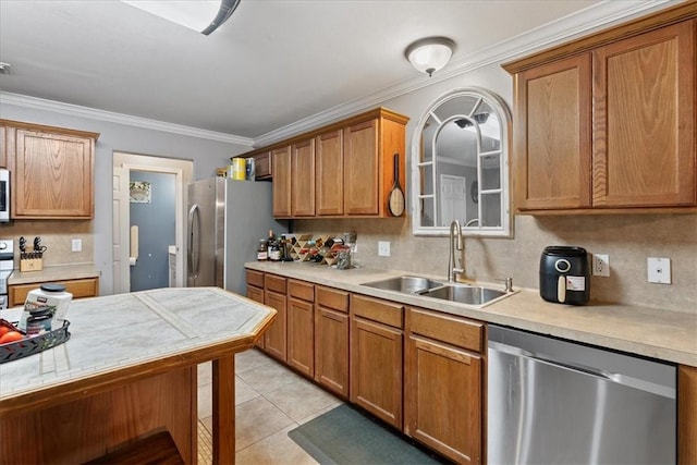 3901 Gibraltar Dr, Corpus Christi, TX 78414 - kitchen featuring stainless steel appliances, a sink, light countertops, ornamental molding, and brown cabinetry