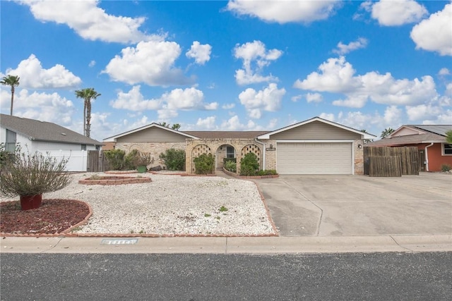 ranch-style house featuring concrete driveway, brick siding, an attached garage, and fence