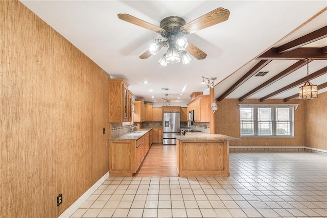 kitchen featuring beam ceiling, stainless steel appliances, visible vents, open floor plan, and a sink