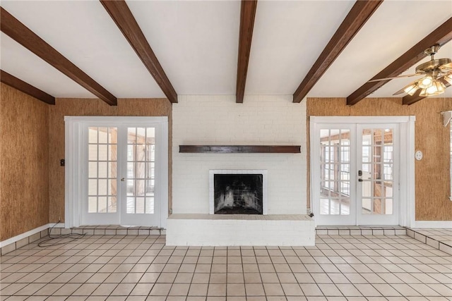 unfurnished living room featuring a fireplace, a ceiling fan, french doors, tile patterned floors, and beamed ceiling