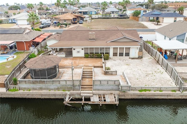 back of house with a deck with water view, a fenced backyard, and a residential view