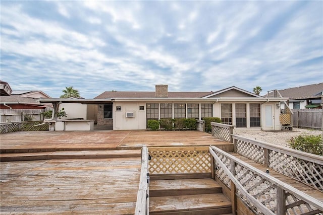 rear view of house featuring fence and a deck