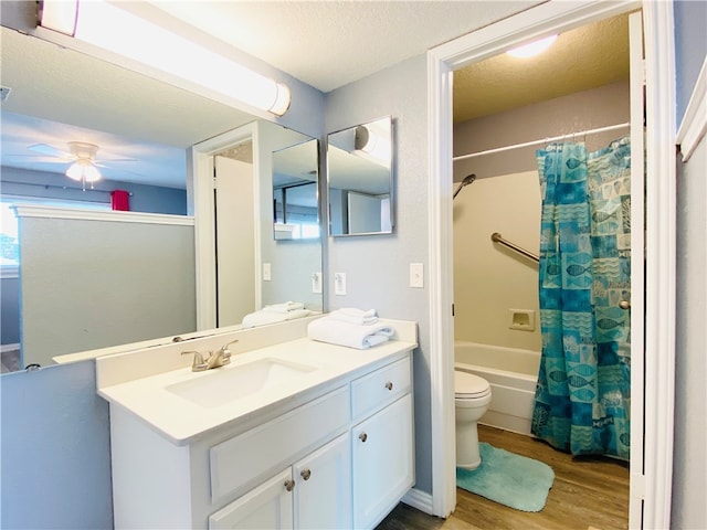 full bathroom with vanity, a textured ceiling, hardwood / wood-style floors, toilet, and ceiling fan