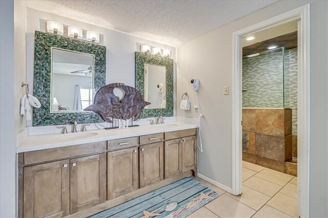 bathroom featuring an enclosed shower, vanity, a textured ceiling, and tile patterned floors