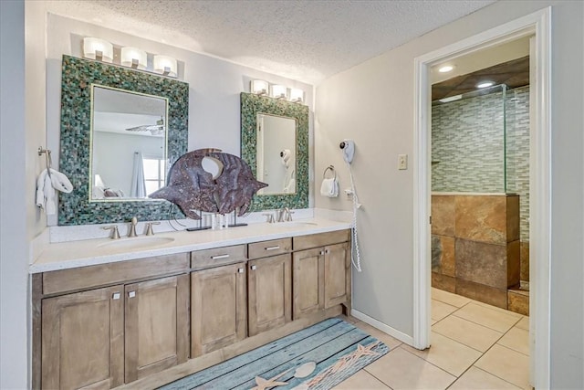 6317 State Highway 361 Unit 3307, Port Aransas, TX 78373 - bathroom featuring a tile shower, double vanity, tile patterned floors, and a textured ceiling
