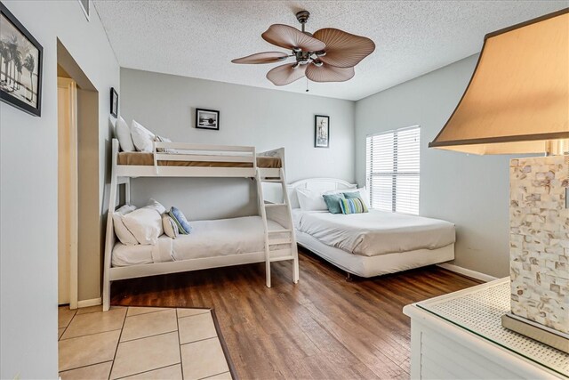 bedroom featuring wood-type flooring, ceiling fan, and a textured ceiling