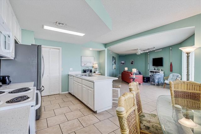 kitchen with white cabinetry, sink, ceiling fan, a textured ceiling, and light tile patterned floors