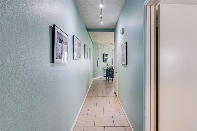 6317 State Highway 361 Unit 3307, Port Aransas, TX 78373 - corridor featuring track lighting, light tile patterned floors, a textured ceiling, a textured wall, and baseboards