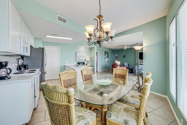 6317 State Highway 361 Unit 3307, Port Aransas, TX 78373 - dining room with light tile patterned floors, a chandelier, baseboards, a ceiling fan, and a textured ceiling