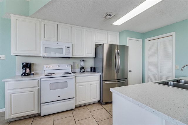 kitchen with white cabinetry, white appliances, sink, and light tile patterned floors