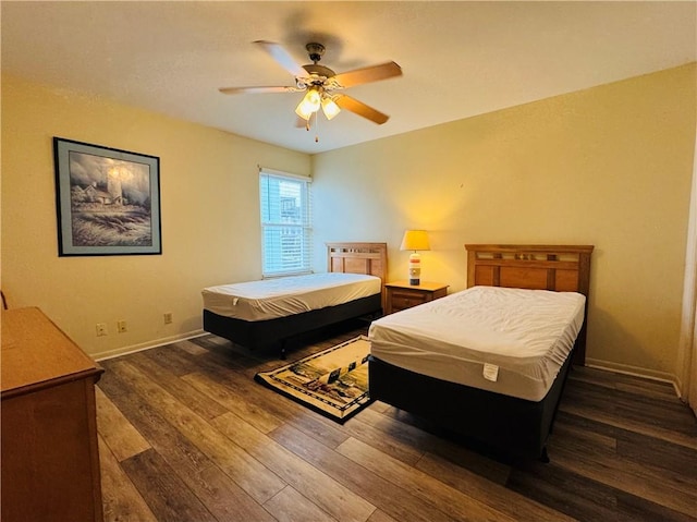 bedroom with dark hardwood / wood-style flooring and ceiling fan