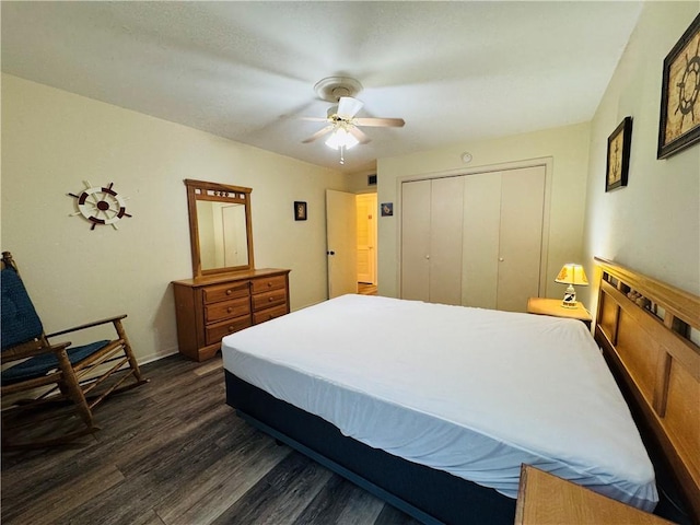 bedroom with ceiling fan, dark wood-type flooring, and a closet