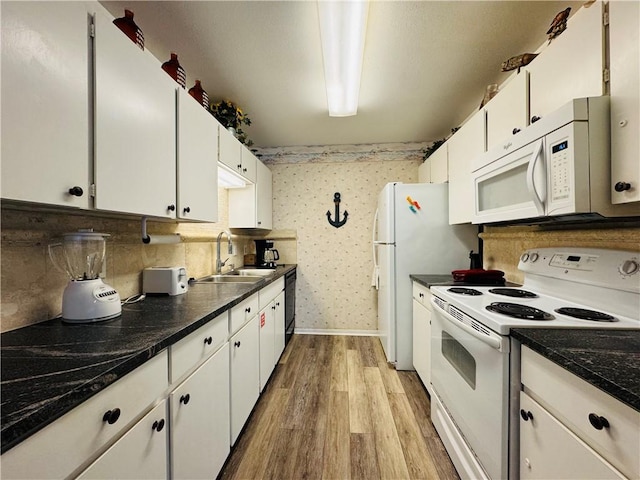 kitchen featuring white appliances, light hardwood / wood-style floors, white cabinetry, and sink