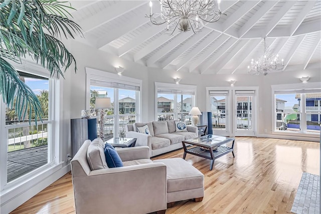 living room featuring a healthy amount of sunlight, a notable chandelier, and light hardwood / wood-style floors