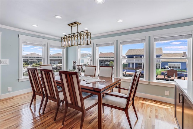 dining space featuring a healthy amount of sunlight, light hardwood / wood-style floors, and crown molding