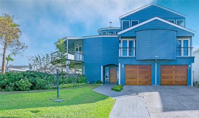 view of front of house with a balcony, a front yard, and a garage