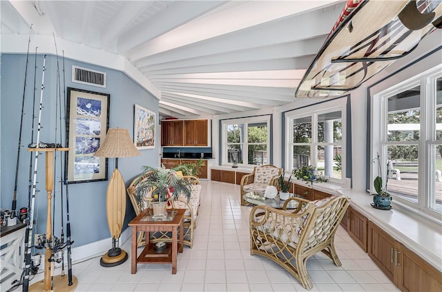 sunroom featuring vaulted ceiling with beams