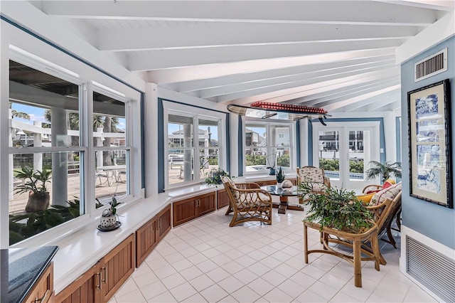 sunroom / solarium featuring vaulted ceiling with beams and plenty of natural light