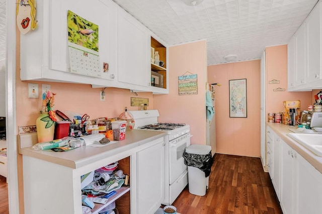 540 Jacoby Ln, Aransas Pass, TX 78336 - kitchen featuring white gas range oven, open shelves, white cabinetry, dark wood-type flooring, and light countertops
