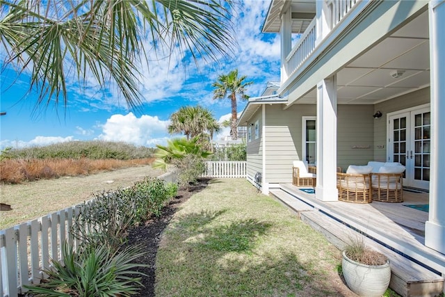 view of yard featuring french doors and fence