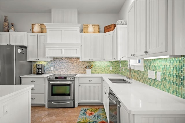 kitchen with a sink, white cabinetry, stainless steel appliances, light countertops, and decorative backsplash