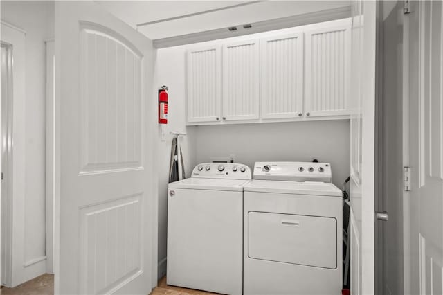 laundry area featuring washer and clothes dryer and cabinet space