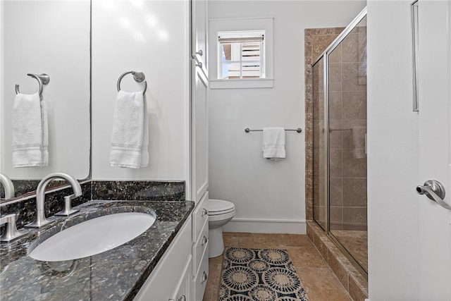 bathroom featuring baseboards, vanity, toilet, and a shower stall