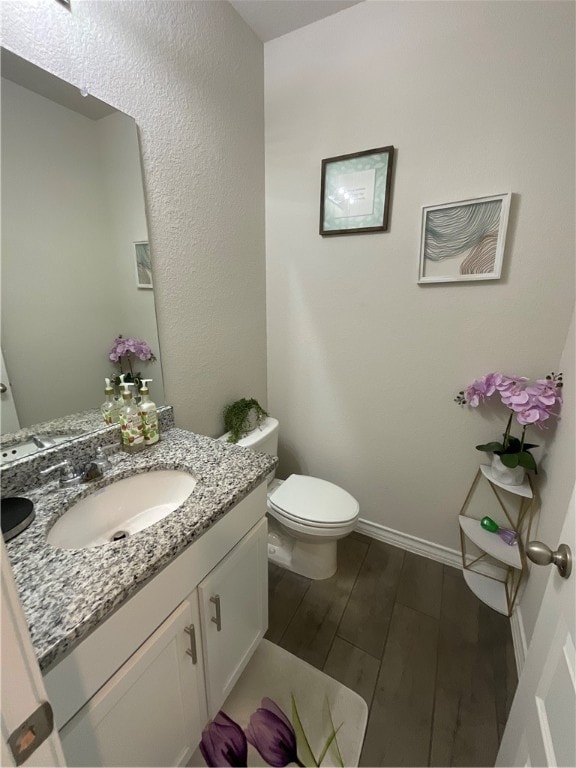 bathroom featuring hardwood / wood-style flooring, vanity, and toilet