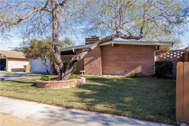 ranch-style home featuring a garage and a front lawn