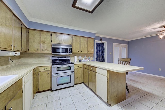 kitchen with kitchen peninsula, a kitchen breakfast bar, a textured ceiling, stainless steel appliances, and light tile patterned floors