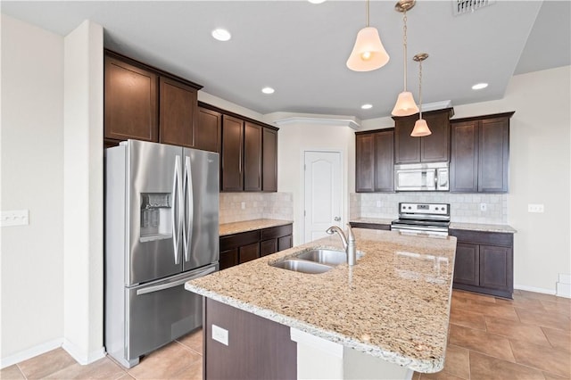 1733 Rhumba Trl, Corpus Christi, TX 78410 - kitchen featuring stainless steel appliances, a sink, dark brown cabinetry, an island with sink, and recessed lighting
