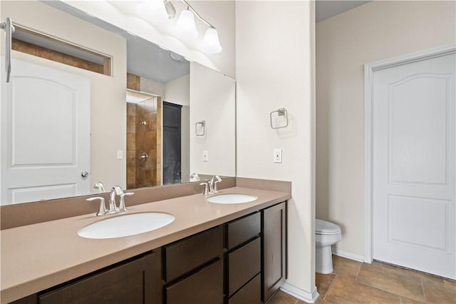 1733 Rhumba Trl, Corpus Christi, TX 78410 - bathroom featuring a tile shower, toilet, double vanity, and baseboards